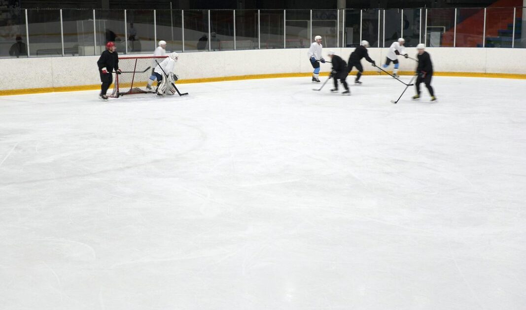 sidney crosby: Dynamic hockey match indoors with players skating and maneuvering on an ice rink