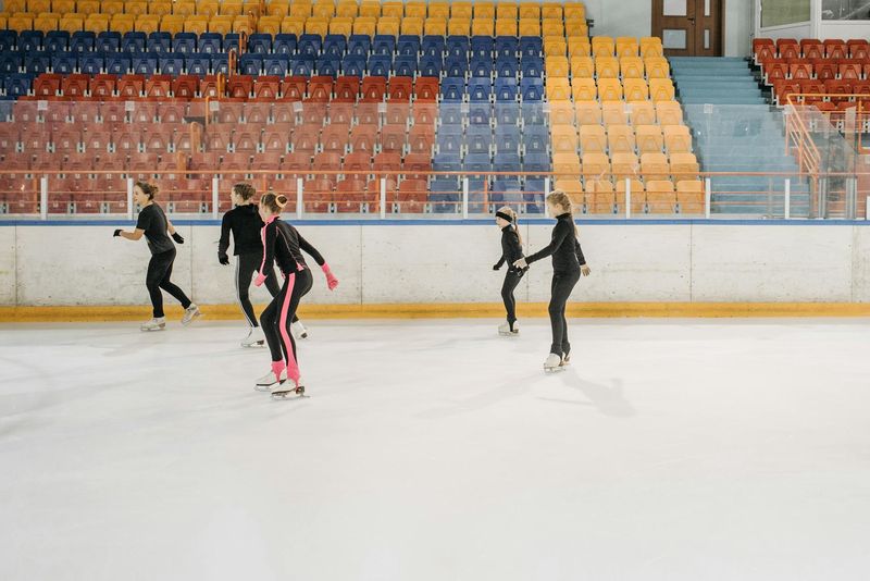 kaori sakamoto: Five young skaters practice figure skating on an indoor ice rink, focusing on