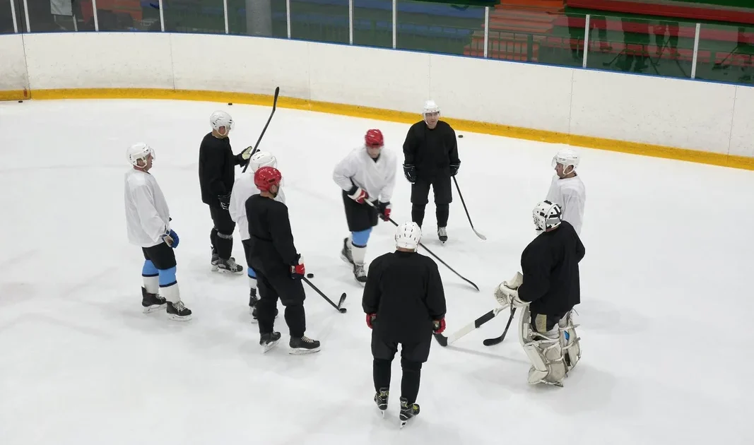 finsko kanada: A team of male ice hockey players gathers on the rink for practice,
